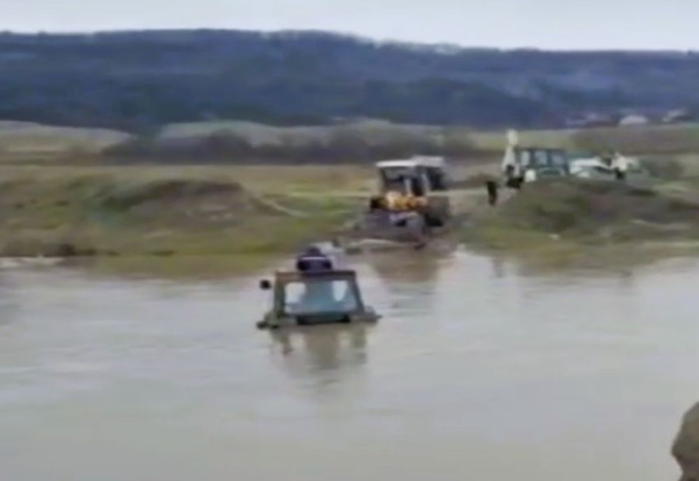 A rămas împotmolit cu tractorul în apa de un metru jumătate